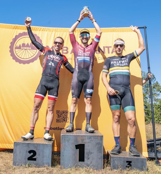 Michael Zinkann on the top step of the podium holding a trophy